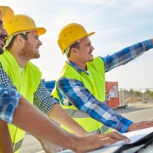 Workers wearing hard hats pointing into the distance