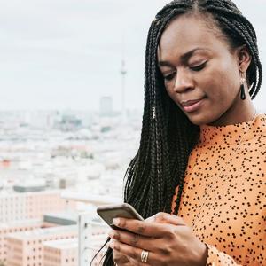 Woman on phone with cityscape behind her