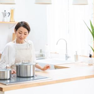 person in white cooking on an electric range