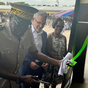 officer cuts the ribbon of a new building with crowd around them