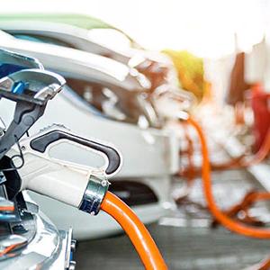 a row of cars plugged in to charging stations