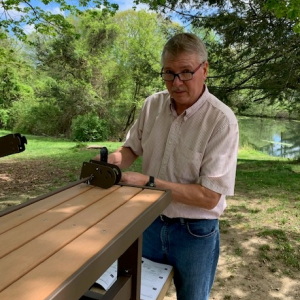 Person stood at the end of a bench outside 