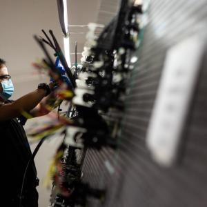 Employee at West Sacamento facility manipulating wires