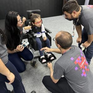 A child in a wheelchair with lenovo employees talking to them