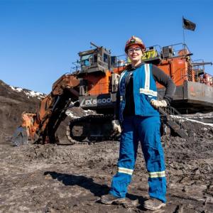 Jenna Plamondon in front of hydraulic shovel