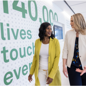 Two people talking and walking down a hallway.