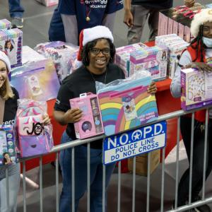 Three people holding up toys