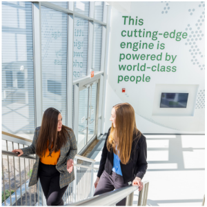 Two people talking as they walk up stairs.