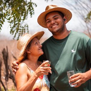 Two people standing together with glasses of water