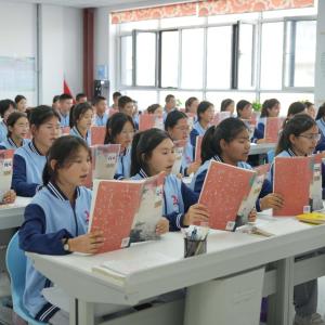 Students sitting in a classroom reading from books