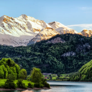 landscape of snow topped mountains down to wooded hills and river
