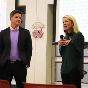 Two people standing behind a podium, one talking.