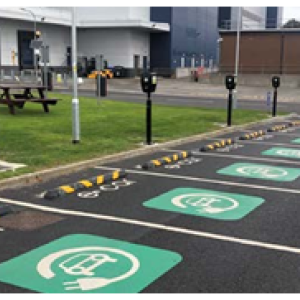 A parking lot with a row of EV charging stations.