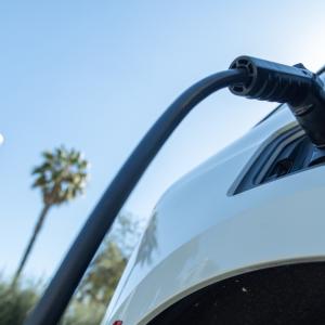 Close up of a vehicle plugged in to an ev charging station.