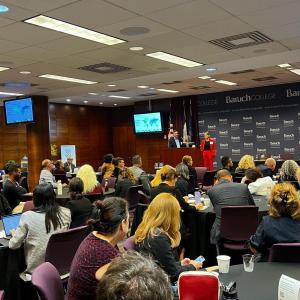 People stood on stage with an audience watching them