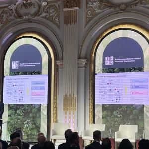 speaker stood at a podium with a presentation behind them