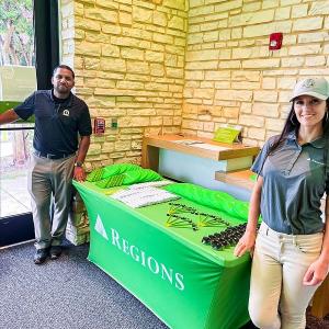 Two people stood either side of a Regions event table 