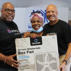 3 people holding a box fan