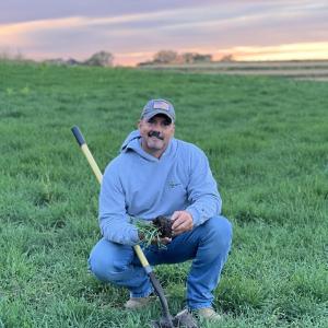 A person crouched in a field of grass.