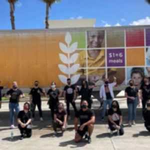 a large group of people in front of a "feeding America" semi trailer outside