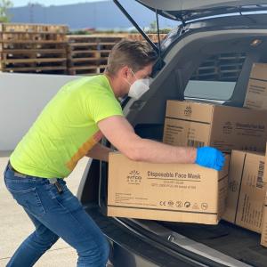 Man loading boxes in a car.