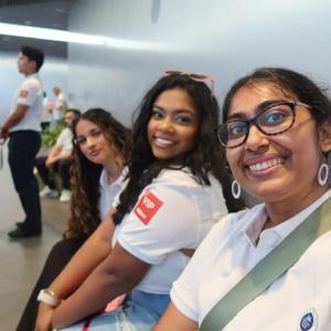 Three people in matching white shirts taking a selfie.