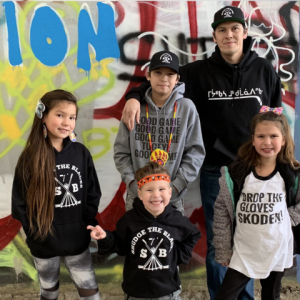 An adult and four children in front of a wall mural