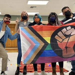 Latino Equity Alliance group with a LGBTQ+ flag