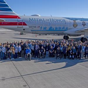 Aerial view of a large group of people in front of the Medal of Honor plane
