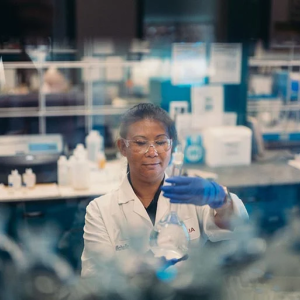 A scientist holding a glass container