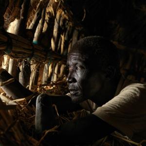 Deng Yell lost both his hands in the war and remains isolated on his floating home. The home is floating due to tightly packing layers of grass on the floor, which acts as a floating pontoon.