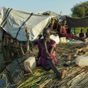 A family sit on their floating pontoon made from tightly packed grass.