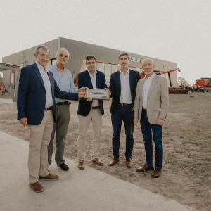Five people standing together outside a dealership