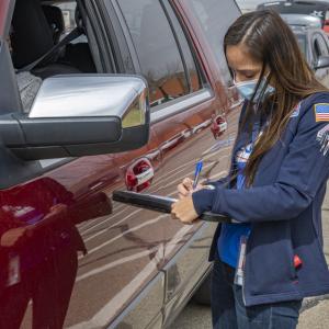 Driver speaking with food bank volunteer who is holding a clipboard