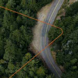 aerial view of a road through dense forest