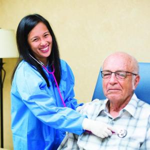healthcare worker listening to a patient's heart with a stethoscope