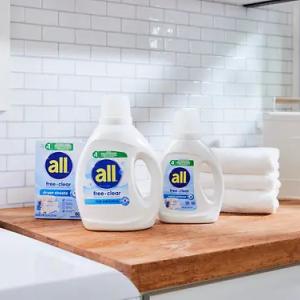 Three bottles of all detergent on a wooden counter.