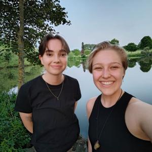 Two smiling people in a park setting.