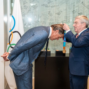 A medal being placed around Gary Hall Jr's neck