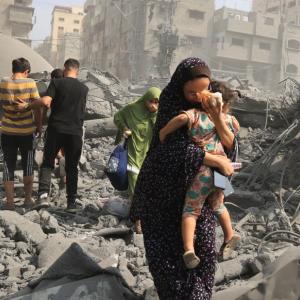 Palestinians evacuate following an airstrike on a mosque in Gaza City. / Photo by Mahmud HAMS, AFP 