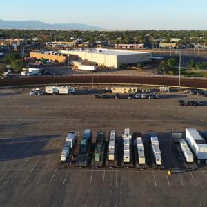 a large parking lot with trailers loaded with large generators