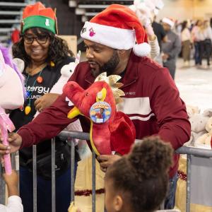 A volunteer handing out toys to children.