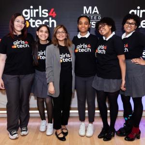 Six people in matching "girls4tech" shirts