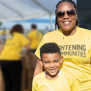An adult and child smiling in matching tshirts.