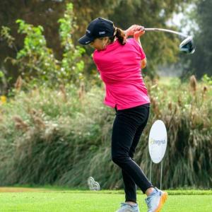 A person swinging a golf club on a course