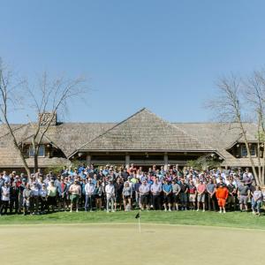 A large group posed on a golf course.