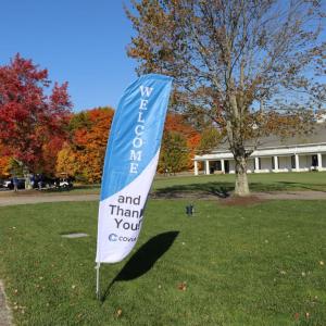A Welcome flag on a lawn outside a golf course.