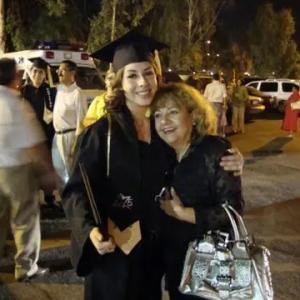 Evila Melgoza in cap and gown hugging another person.