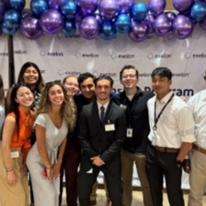 A group of people stood together in front of a balloon arch