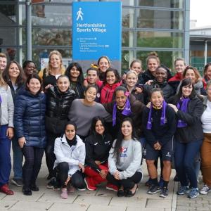 A large group of people outside a building close together for a group shot